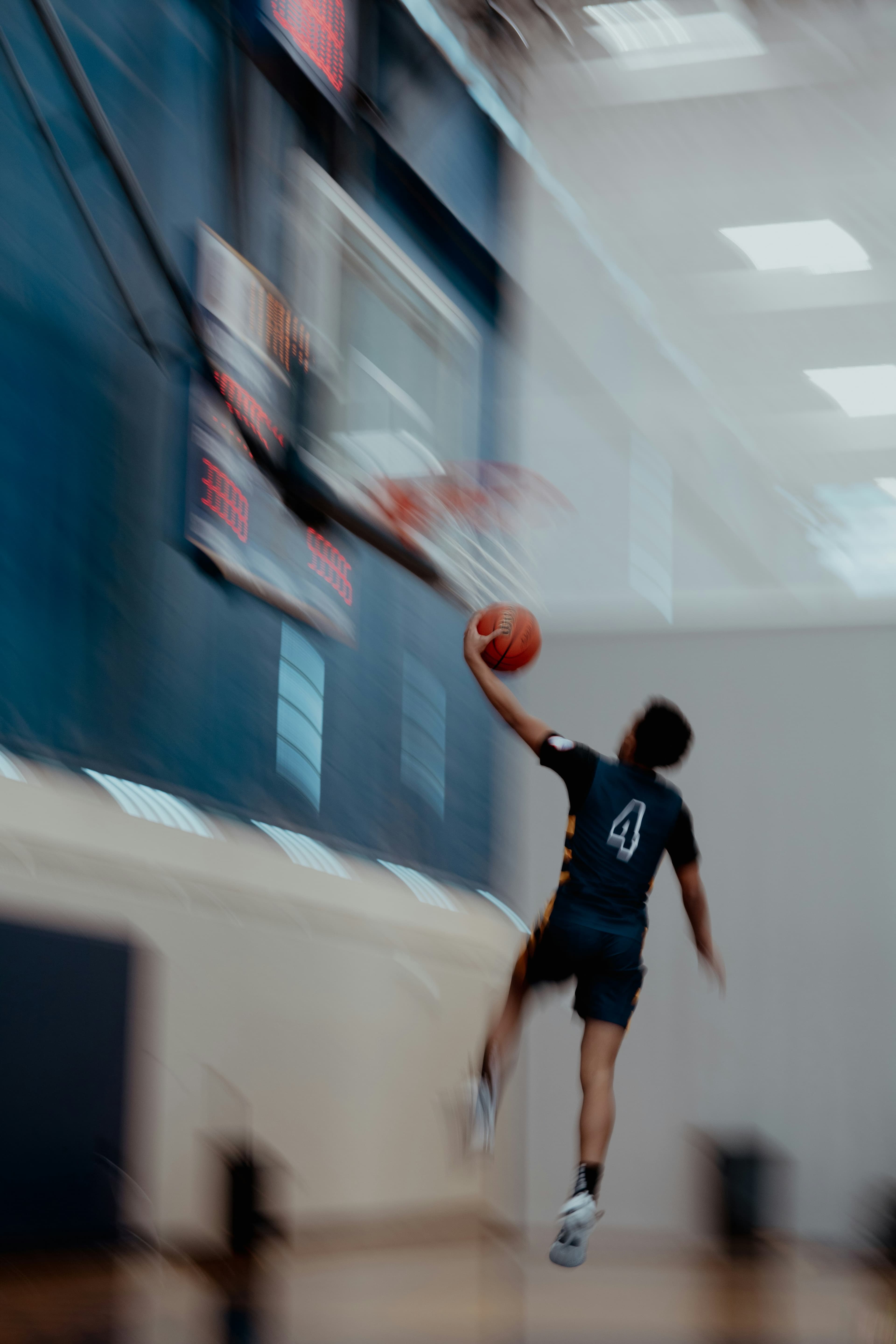 Athlete mid-dunk with motion blur