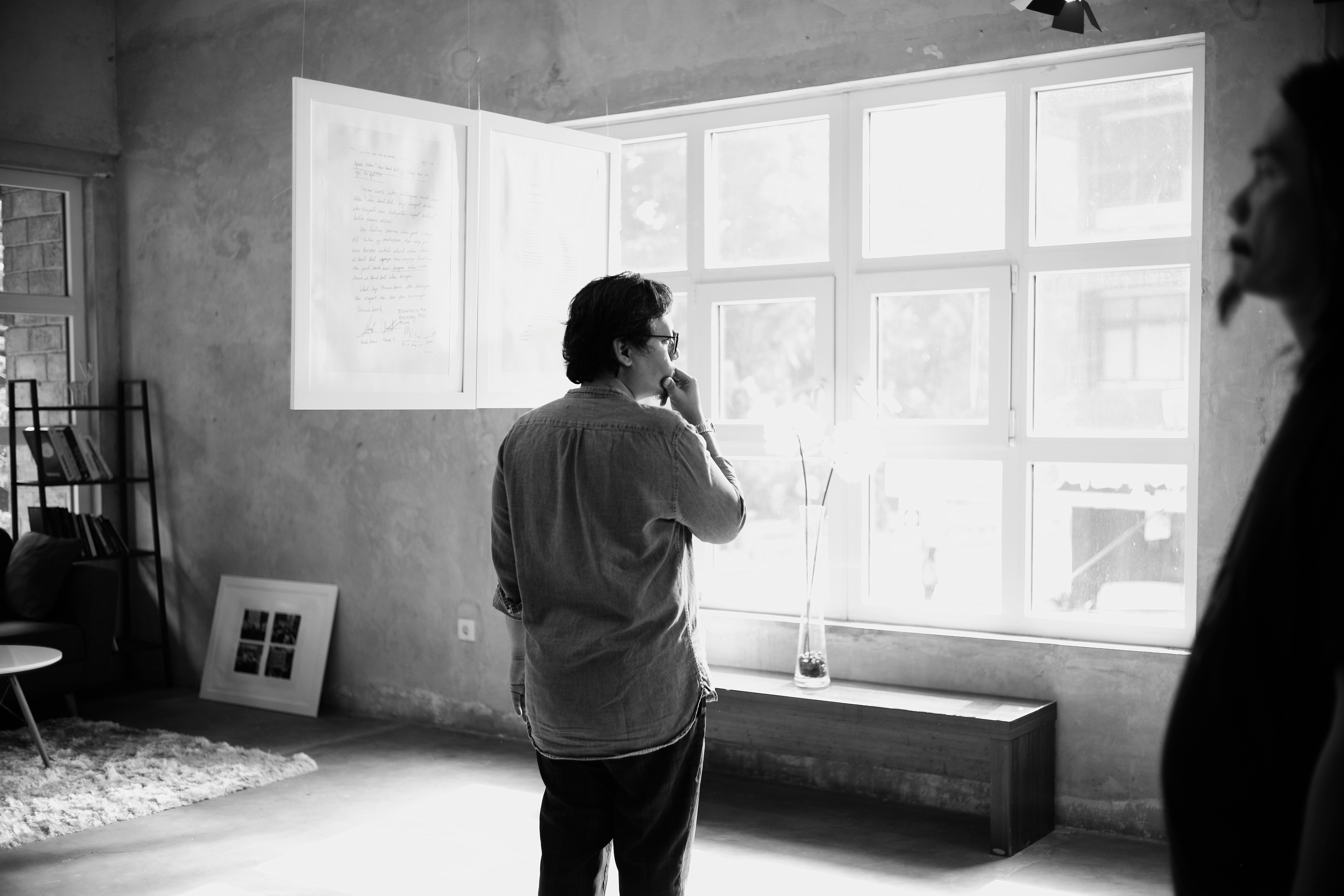 A person standing quietly in a light-filled space